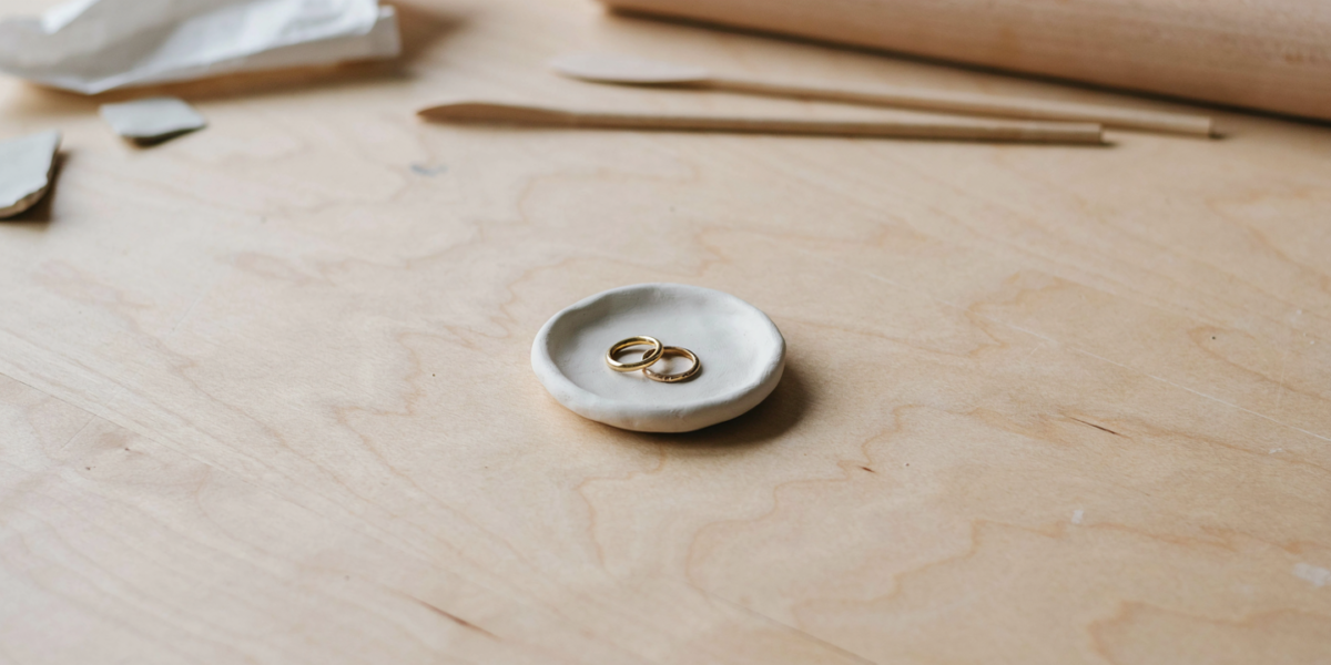 A small white air dry clay trinket dish holding rings