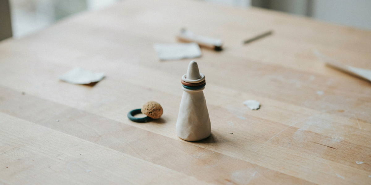 A smooth white clay ring cone holding stacked rings