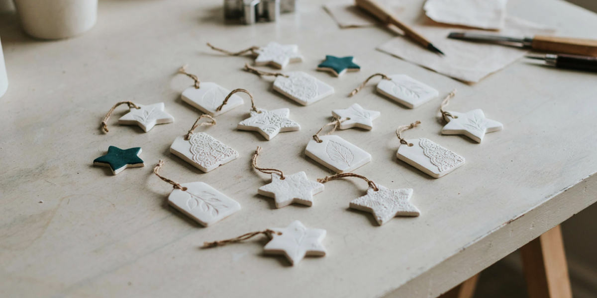 Flat white clay gift tags and star ornaments with pressed leaf patterns