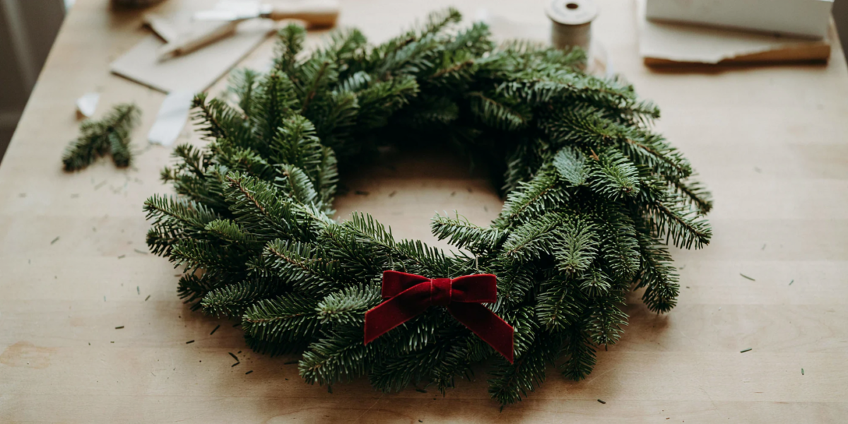 A full classic fir wreath with a simple deep red velvet bow