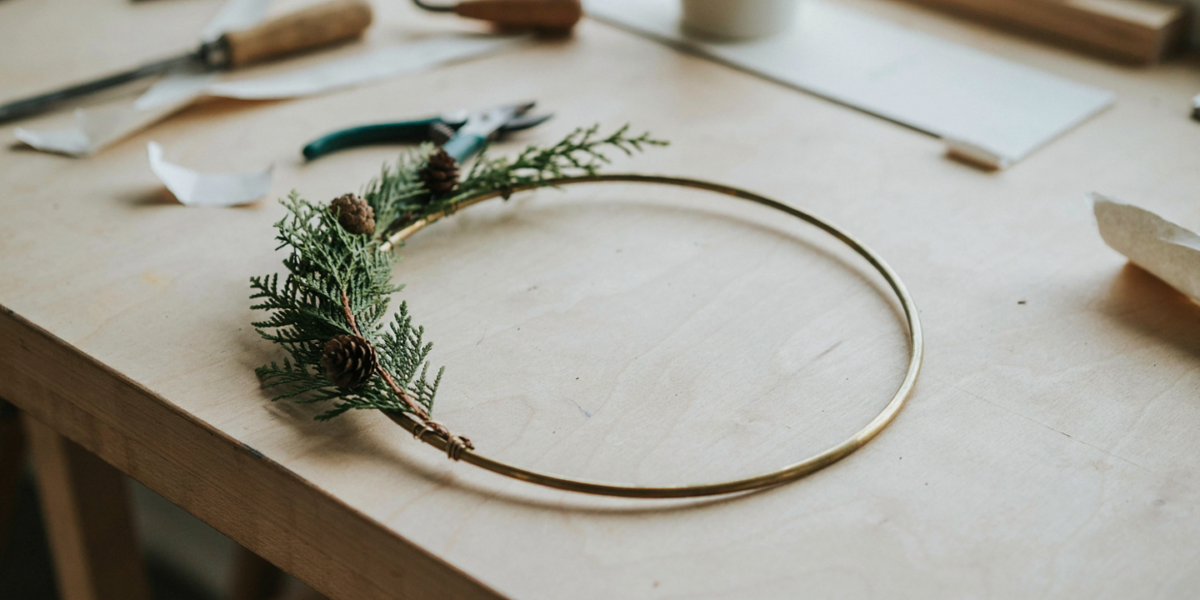 A thin brass hoop with a spray of cedar and eucalyptus on one side