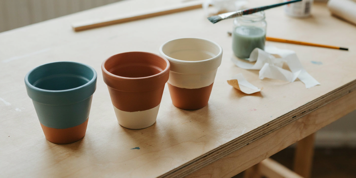 Terracotta pots painted with color-blocked bases and stripes