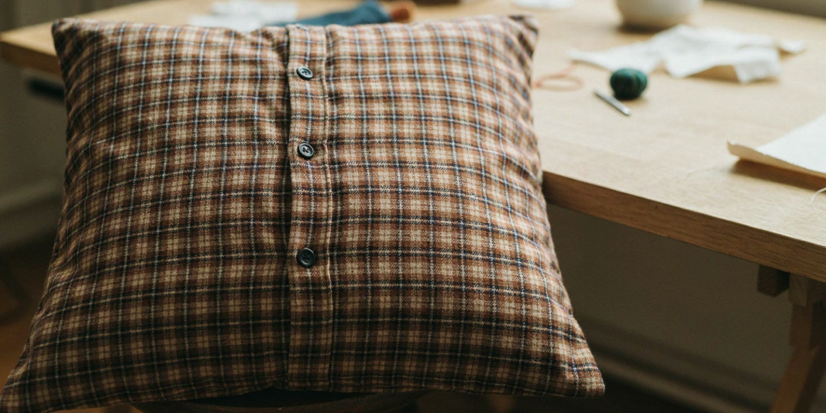 A flannel shirt made into a square pillow cover with the buttons on the back