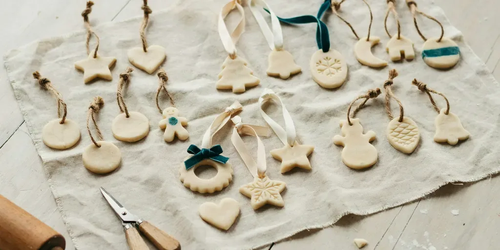 Finished salt dough ornaments threaded with linen ribbon and twine, laid out in rows on linen